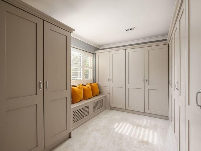 Fitted wardrobes provide storage in the room that was previously used as the fourth bedroom.