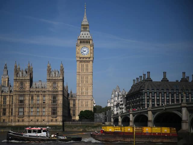 A tow boat goes past Palace of Westminster, home to the Houses of Parliament, and the Elizabeth Tower. PIC: DANIEL LEAL/AFP via Getty Images