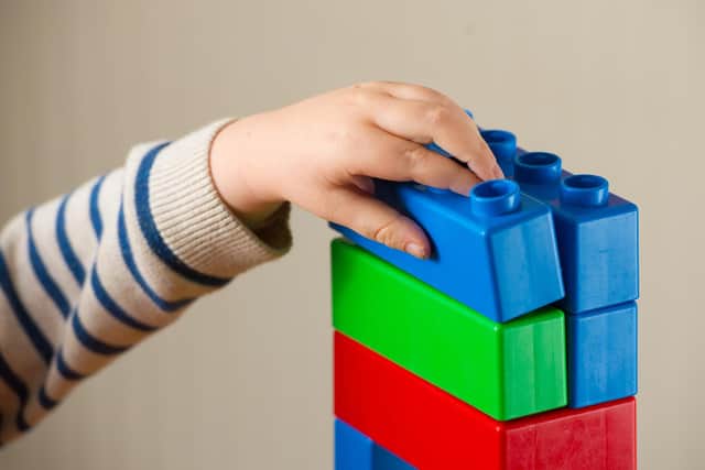 A preschool age child plays with plastic building blocks. PIC: Dominic Lipinski/PA Wire