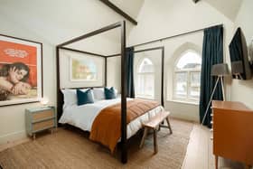 One of the most spectacular bedrooms with a four poster, ecclesiastical windows and a poster with a quote from Frida Kahlo