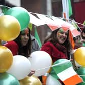 People bearing the colors of Ireland and smile during the St Patrick's Day parade. (Pic credit: Carl Court / AFP via Getty Images)