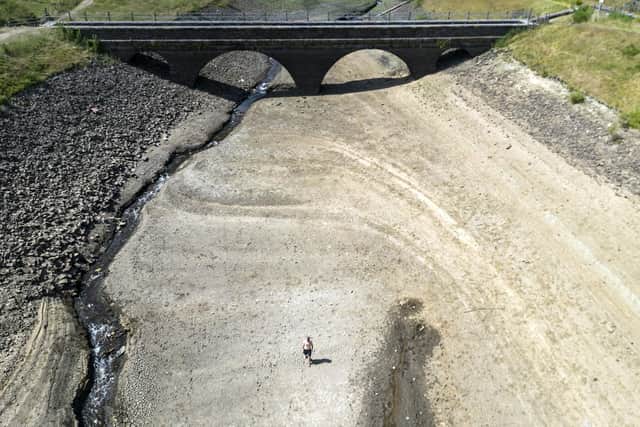 A person walks a dry bank of a tributary to the Dowry Reservoir close to Oldham, during last summer's heatwave in the UK. Picture date: Monday July 18, 2022. PIC: Danny Lawson/PA Wire