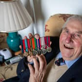 Former Royal Navy Commander Eric Verge, 97, of Guiseley, near Leeds, was the Queens Colour Officer on The Mall, London, for the Queens Coronation on 2nd June 1953. Pictured Eric, with his military medals and far-right the medal issued to him for taking part in the Queens Coronation. Picture By Yorkshire Post Photographer,  James Hardisty. Date: 3rd May 2023.