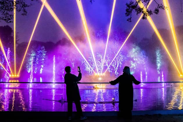 People view an installation over a lake that forms part of the Enchanted Forest Winter Illuminations at Stockeld Park in Wetherby, North Yorkshire.