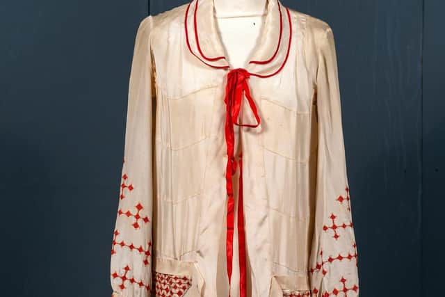 Circa 1920s cream silk day coat/dress with double peter pan collar trimmed with red silk, and red embroidered diamonds. Sold with crca 1920s American brown wool evening coat. Estimate: £200-300 plus buyer’s premium. Picture Bruce Rollinson.