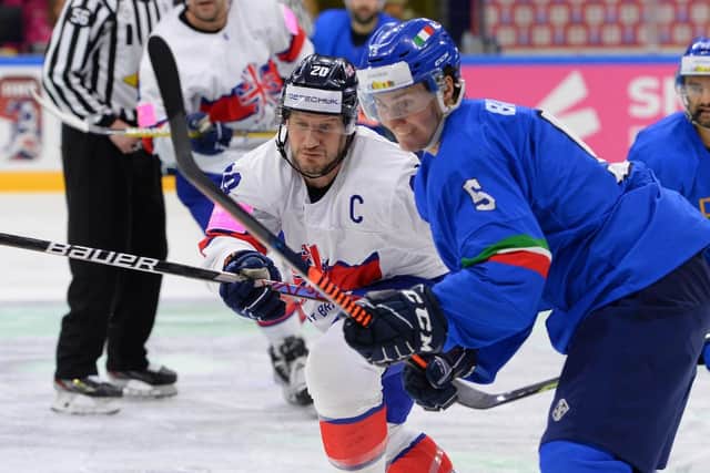 LEADING FROM THE FRONT: Jonathan Phillips (left) battles for puck possession against Italy at Nottingham's Motorpoint Arena on Friday night in their IIHF World Championship Division 1A promotion decider. Picture courtesy of Dean Woolley/Ice Hockey UK
