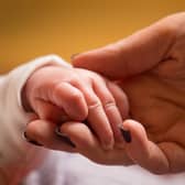 A mother holds the hand of a new-born baby. PIC: Dominic Lipinski/PA Wire