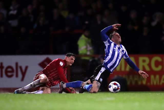 Sheffield Wednesday's Lee Gregory goes down under pressure from a Cheltenham defender. Picture: PA.