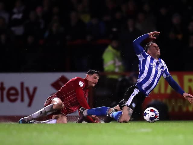 Sheffield Wednesday's Lee Gregory goes down under pressure from a Cheltenham defender. Picture: PA.