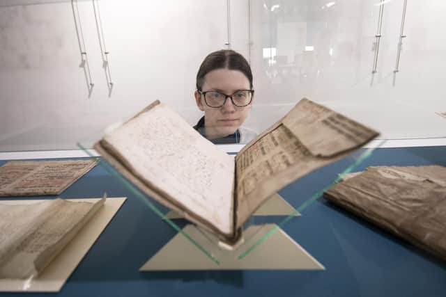 Conservation Volunteer Paula Madej looks at the book of Recycle Music 1400-1500s