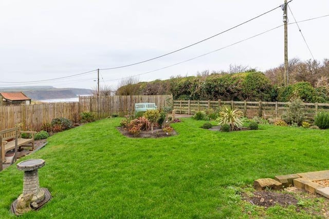 A wider angle view of the garden with sea and cliff top views