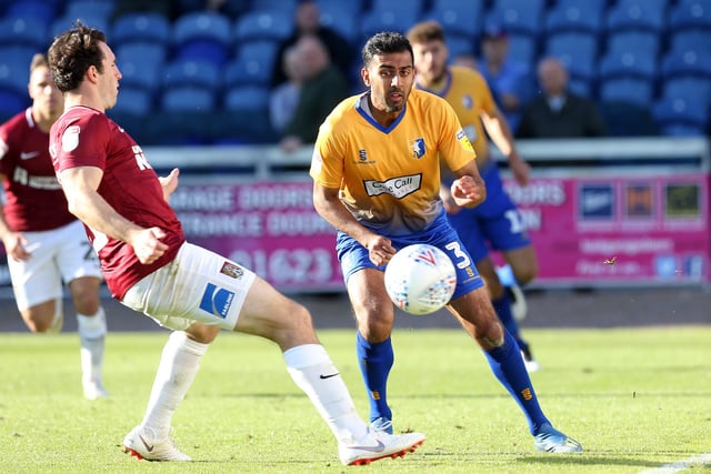 Mal Benning of Mansfield Town plays the ball past John-Joe O'Toole of Northampton Town during the Sky Bet League Two match between Mansfield Town and Northampton Town at The One Call Stadium on September 29, 2018.