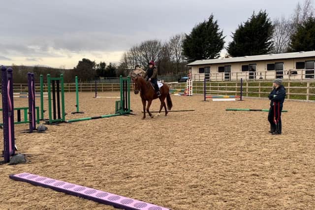 Katie Boddy of Sproxton Grange Equestrian Centre near Helmsley in the ring watched by Pauliina Swindells who has been assisting with the re-training of two former race-horses.