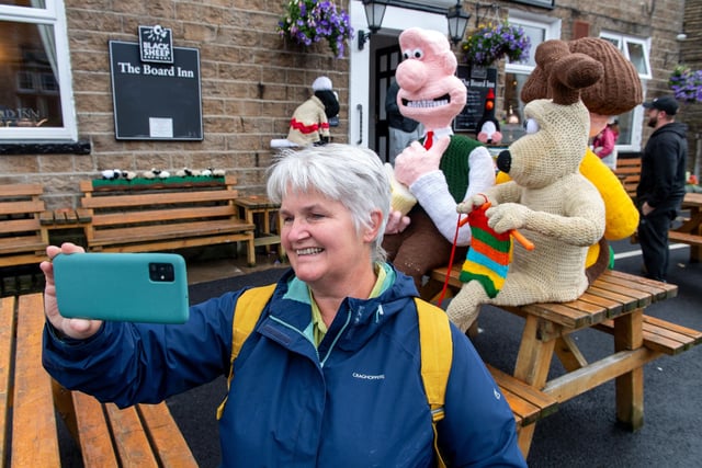 Irene Crow takes a selfie with the characters outside The Board Inn.