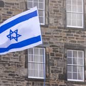 A protester waves an Israeli flag. PIC: Lesley Martin/PA Wire