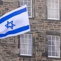 A protester waves an Israeli flag. PIC: Lesley Martin/PA Wire