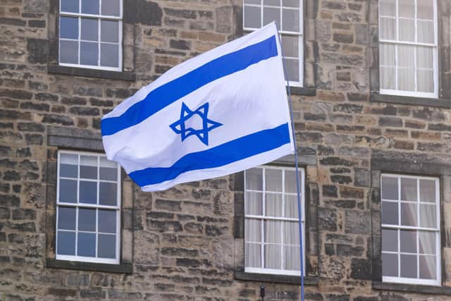 A protester waves an Israeli flag. PIC: Lesley Martin/PA Wire