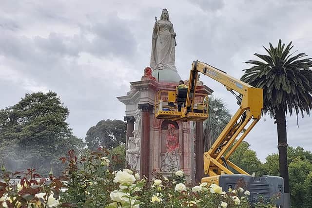 A council worker cleans the statue to Britain's Queen Victoria that was defaced in the Royal Botanic Gardens Victoria in Melbourne on January 25, 2024, ahead of Australia Day. (Photo by Martin PARRY / AFP) (Photo by MARTIN PARRY/AFP via Getty Images)
