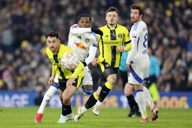 Leeds United's Largie Ramazani (centre left) and Harrogate Town's Levi Sutton (left) battle for the ball during the Emirates FA Cup third round match at Elland Road. Photo: Barrington Coombs/PA Wire.