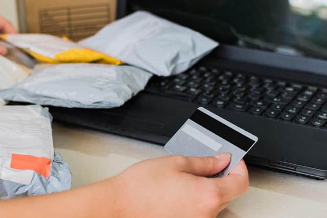 A woman holding a credit card and making an online purchase using a laptop. PIC: Alamy/PA