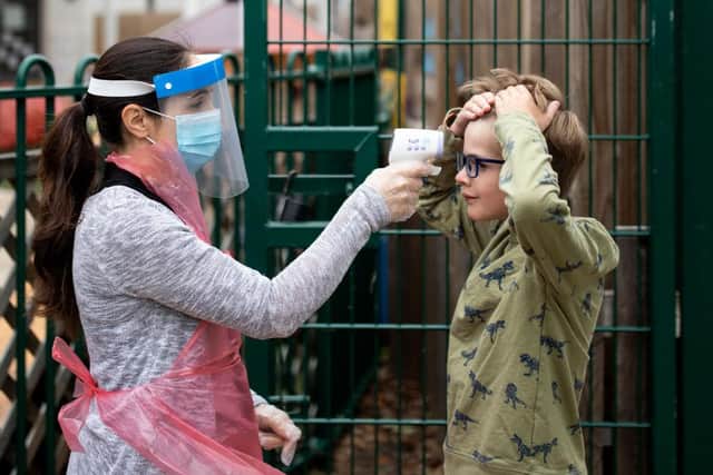 A member of staff wearing takes a child's temperature at a school in June 2020 (Photo: Dan Kitwood/Getty Images)