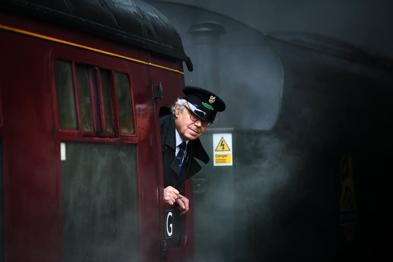 The conductor of the Royal Scot looks out as the train pulls into Pickering station.