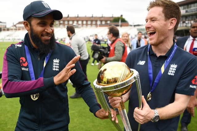 Adil Rashid and England captain Eoin Morgan as he carries the World Cup trophy during a victory event at The Oval in London on July 15, 2019, a day after they won the 2019 Cricket World Cup final against New Zealand (Picture: DANIEL LEAL/AFP via Getty Images)