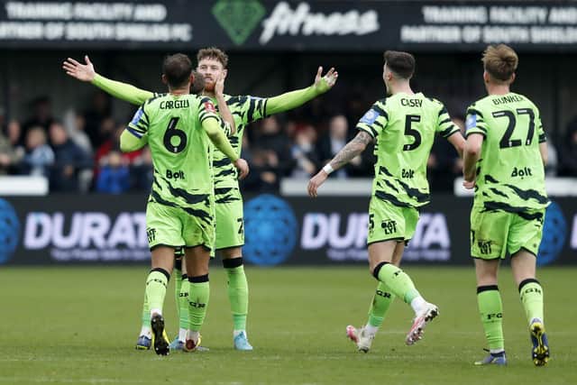 Forest Green Rovers' Connor Wickham celebrates with his team-mates after scoring their side's second goal of the game during the Emirates FA Cup first round match at the 1st Cloud Arena, South Shields. Picture: Will Matthews/PA