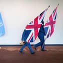 UN staff remove United Kingdom flags from a podium. PIC: Stefan Rousseau/PA Wire