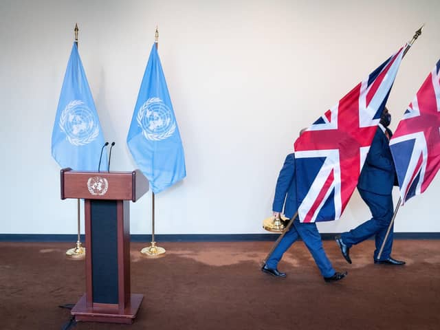 UN staff remove United Kingdom flags from a podium. PIC: Stefan Rousseau/PA Wire