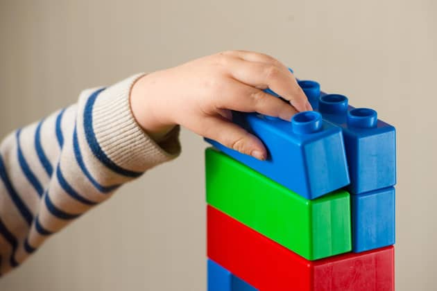 A preschool age child playing with plastic building blocks. PIC: Dominic Lipinski/PA Wire