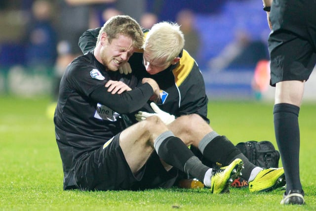 Agony for Mansfield striker Alex Fisher following a nasty shoulder injury.