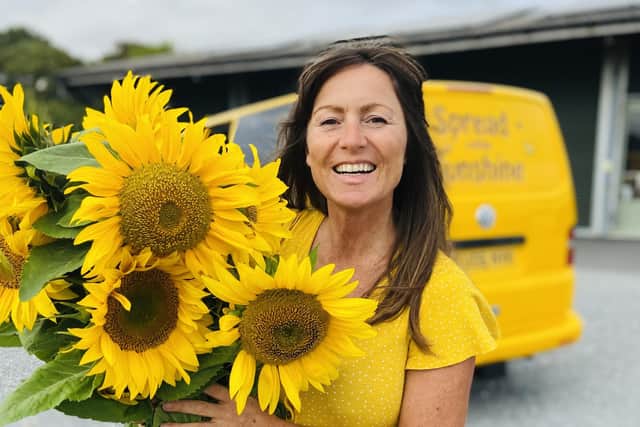 Kelly Williams with her sunflowers and bright yellow van.