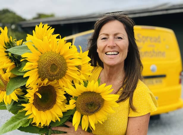 Kelly Williams with her sunflowers and bright yellow van.
