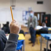 A pupil raises their hand during a lesson. (Pic credit: Matthew Horwood / Getty Images)