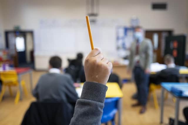 A pupil raises their hand during a lesson. (Pic credit: Matthew Horwood / Getty Images)