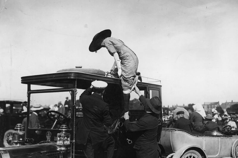 A spectator climbs onto the roof of a car for a better view at the Harrogate leg of the Round Britain Air Race in July 1911.