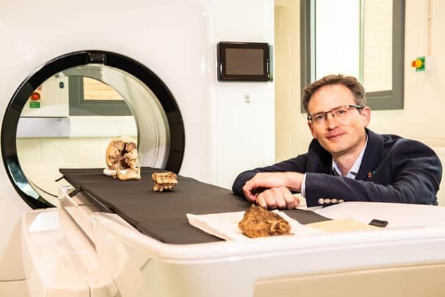 Professor Andrew Wilson with the FujiFilm NewTom Cone Beam CT scanner, showing a cranium and vertebrae from the university collections. Also a mummified hawk (front) on loan from Bradford District Museums and Galleries. KM Images Ltd