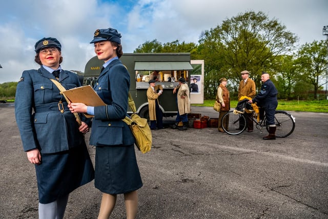 Pictured (left) Charis Hawley (WAAF), and Charlie Huxley-James, (WAAF Oficer), both members of Tail-End Charlies Re-Enacting group keeping check with personnel on site, whilst others enjoy refreshments from the mobile NAAFI trcuk. Picture By Yorkshire Post Photographer,  James Hardisty.