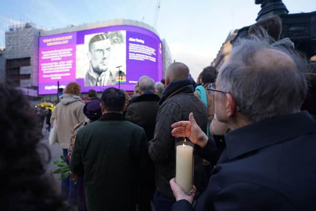 Dr Martin Stern, a survivor of the Holocaust (right) holds a lit memorial candle at Piccadilly Circus, central London, as a selection of entries from the Holocaust Memorial Trust's (Extra)Ordinary Portraits competition, as well as new photographs of genocide survivors taken by photographer Rankin, are shown on the video screens, to mark Holocaust Memorial Day. Picture date: Friday January 27, 2023. PA Photo. See PA story MEMORIAL Holocaust. Photo credit should read: James Manning/PA Wire 