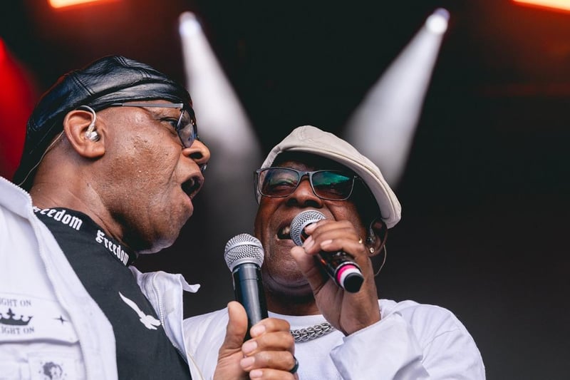 Original members of The Real Thing Chris Amoo and Dave Smith singing on stage.