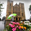 A girl with her Umbrella walks through heavy rain at Ripon Cathedral. PIC: Simon Hulme