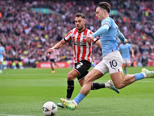 Manchester City's English midfielder Jack Grealish (R) crosses past Sheffield United's English defender George Baldock during the English FA Cup semi-final (Picture: GLYN KIRK/AFP via Getty Images)
