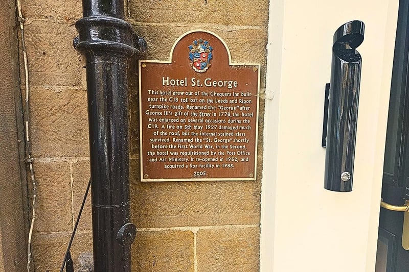 A plaque inscribed with historic information about St George's Hotel.