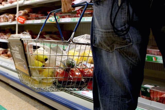 A person holding a shopping basket in a supermarket. PIC: Julien Behal/PA Wire