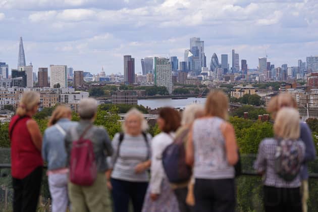People admiring the view of the London skyline from the top of Greenwich Park, in London. Picture: Yui Mok/PA Wire