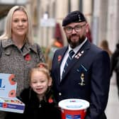 Ivy Knighton-Leake, 6, one of the UK's youngest collectors, holds one of four special poppies presented to her during the Royal British Legion Poppy Appeal 2026 national launch at Manchester Victoria Station, as she stands with her parents, Kimberley Leake and Steven Knighton.