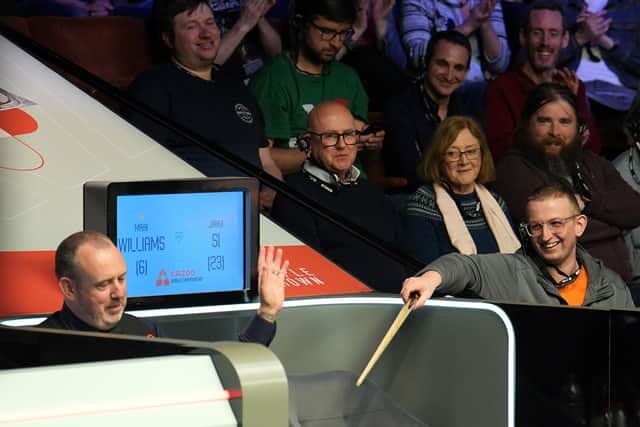 Mark Williams hands his cue to a spectator during his match with Si Jiahui at the Cazoo World Snooker Championship at the Crucible Theatre, Sheffield. Picture: Martin Rickett/PA Wire.