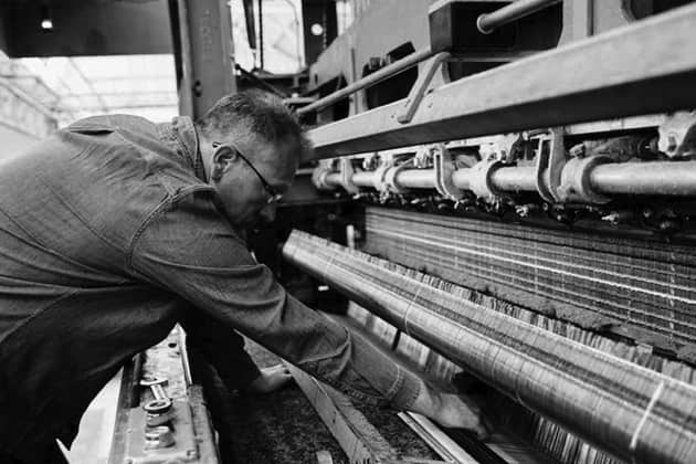 A man operates a machine at textile manufacturer Abraham Moon & Sons. Photo: Lloyd Almond Productions/Campaign for Wool
