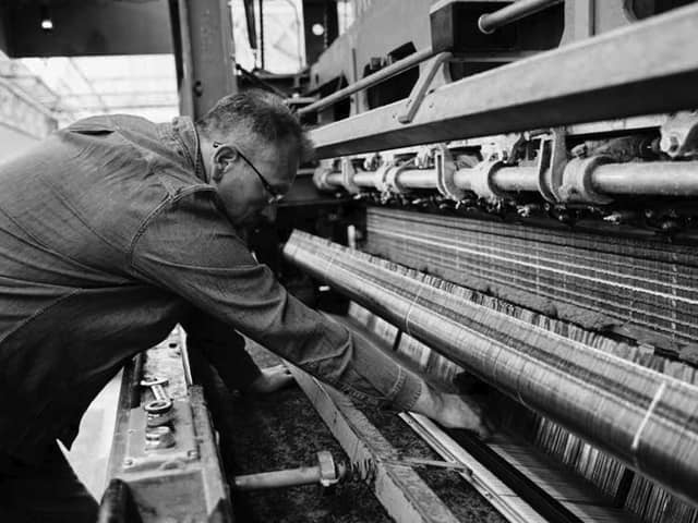 A man operates a machine at textile manufacturer Abraham Moon & Sons. Photo: Lloyd Almond Productions/Campaign for Wool